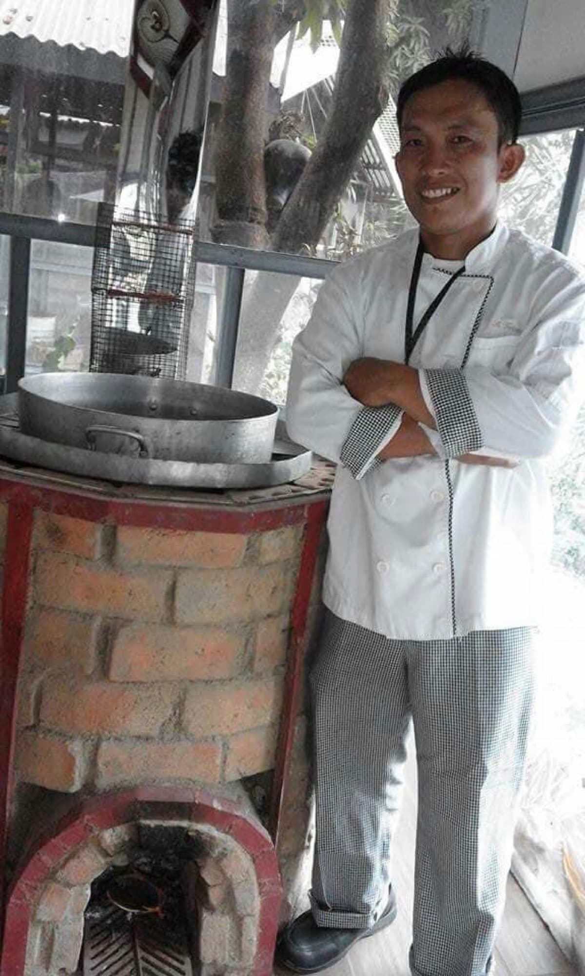 A chef beside a brick stove at the Earth Kitchen