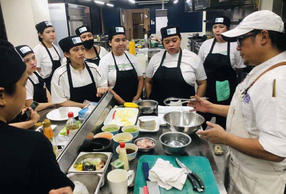 A chef instructing students at a Green Chefmanship kitchen class