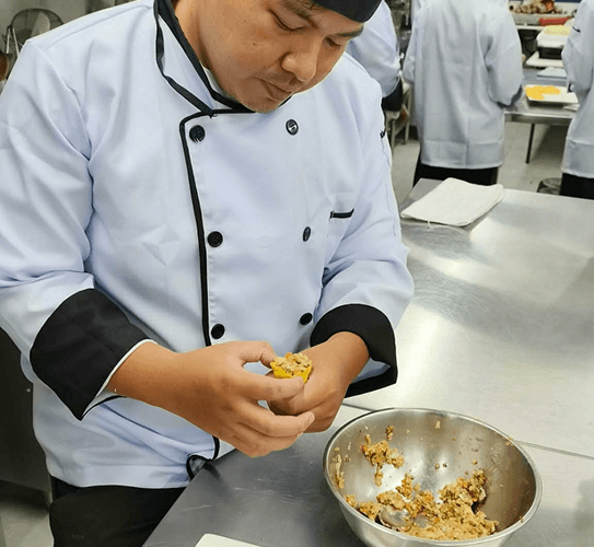A chef preparing food during a Rotary Club partnership training